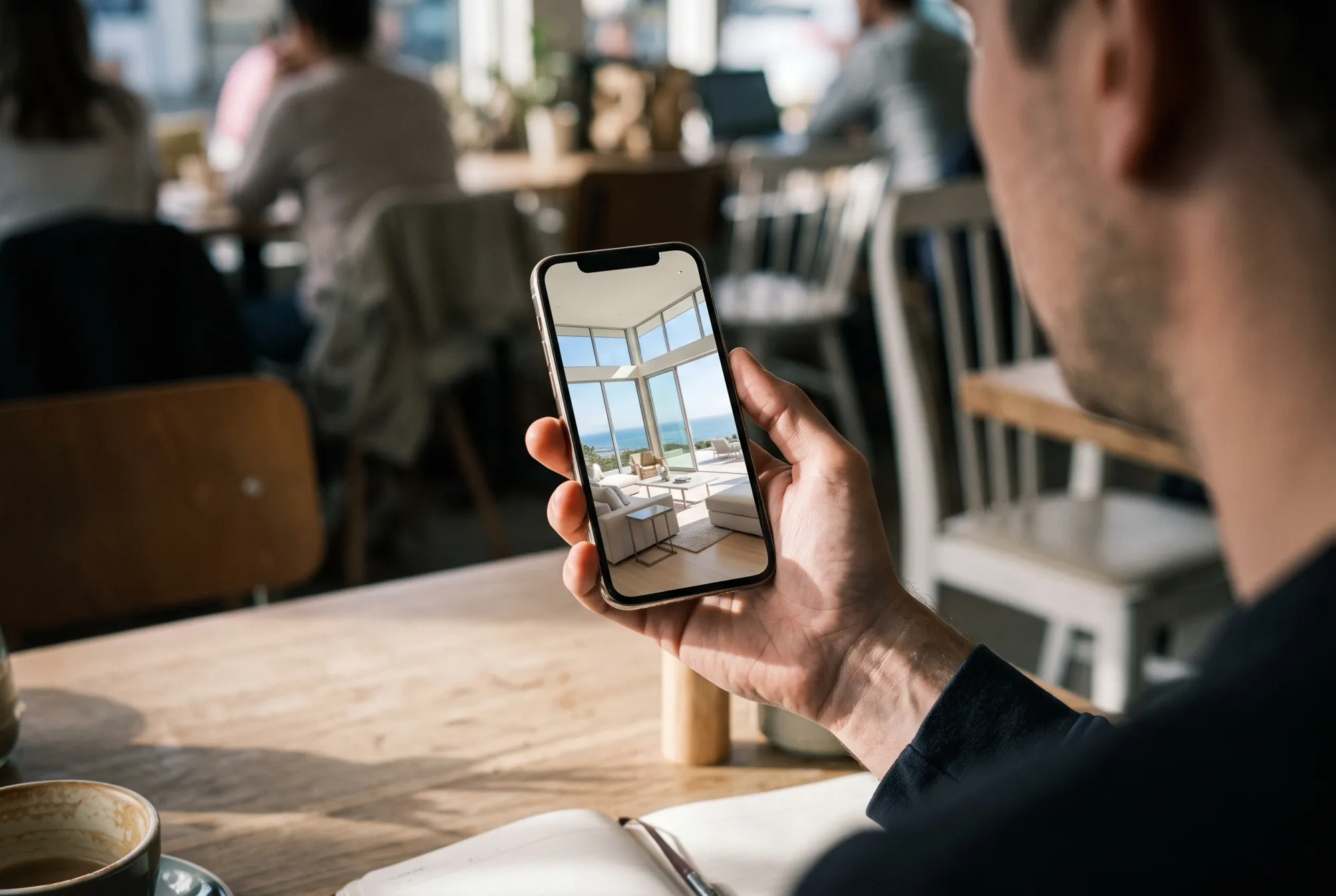 Person scrolling through a photo of a luxury living room on a phone.