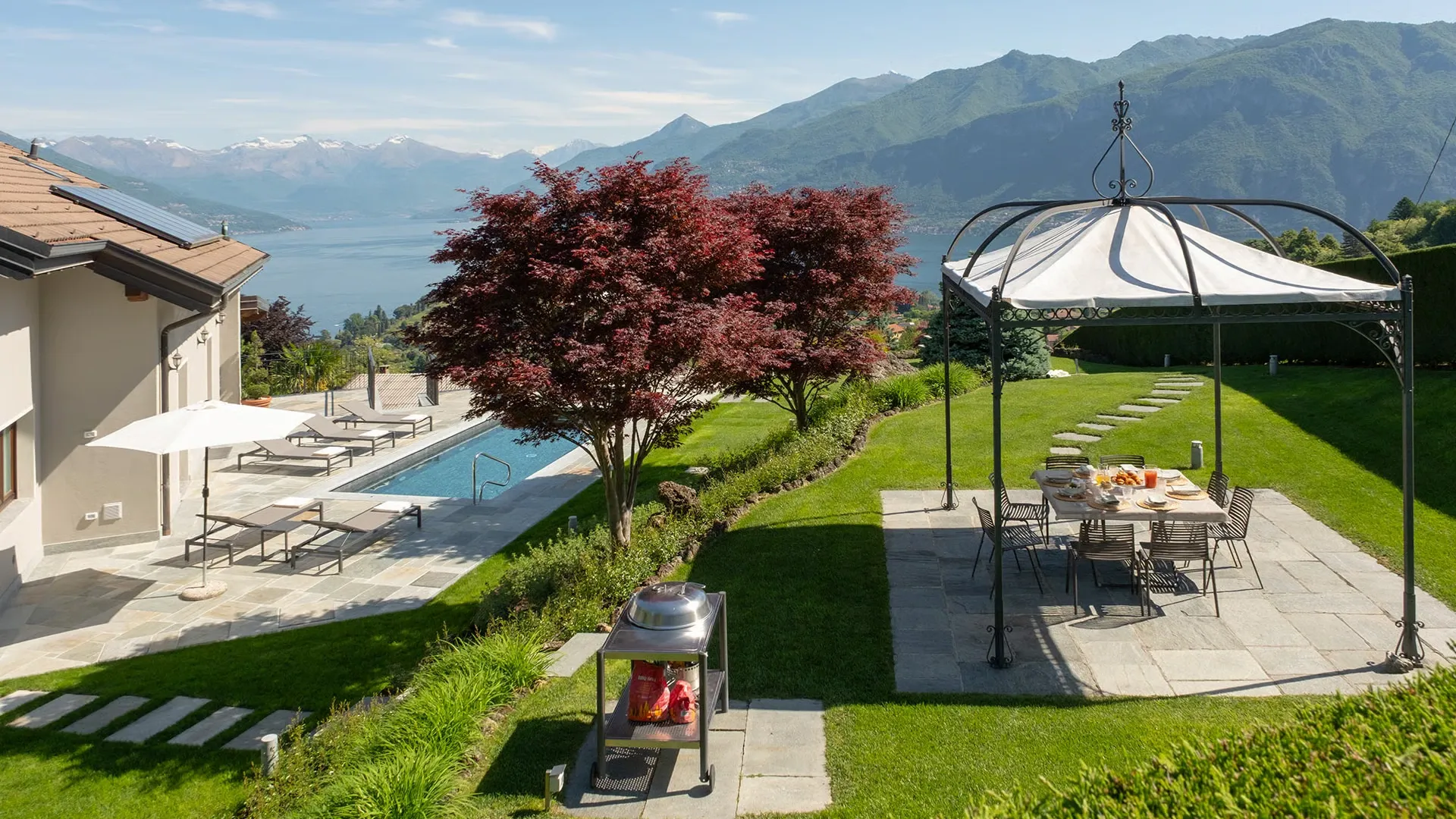 Villa Ugo's terrace and pool above Bellagio, looking out over Lake Como toward the mountains.